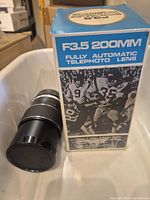 Lens with front cap beside box front panel