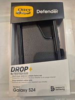 Front of retail package showing OtterBox Defender branding and visible black case