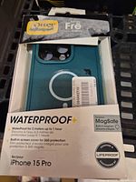 Front of open box showing teal case and Waterproof+ specification