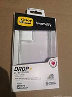 Front of sealed retail package showing OtterBox Symmetry clear case