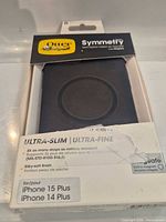 Front of unopened OtterBox Symmetry Series case packaging showing black MagSafe case and compatibility for iPhone 15 Plus/14 Plus