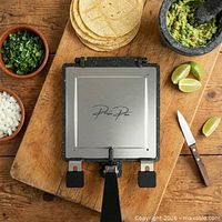 Closed press with stainless lid next to tortillas and guacamole