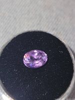 Top view of oval-cut amethyst on black foam pad