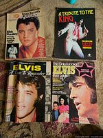 Four Elvis Presley magazines laid out on carpet