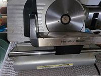 Front view showing Hamilton Beach logo, blade, carriage, base