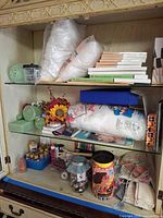 Overall cabinet view showing canvases, fiberfill, floral foam, paints, buttons, socks, yarn