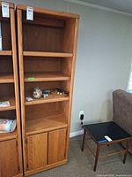 Full view of tall oak bookshelf next to another unit