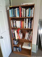 Front view of tall pressed wood bookcase with five shelves