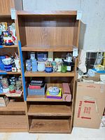 Front view of brown pressed wood laminate bookshelf, five shelves