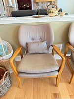 Front view of chair showing wood frame, seat cushion, lumbar pillow, backrest