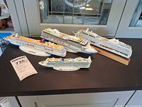 Four ceramic cruise ship models on countertop