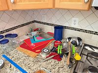overview of lot on countertop showing cutting boards, canisters, utensils, sharpener