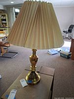 Full view of brass-tone table lamp with shade