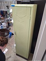 Full view of tall light green metal cabinet with door closed