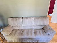 Front view of beige overstuffed sofa