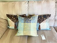 Three decorative pillows on sofa