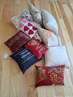 Group shot of all ten pillows on wooden floor