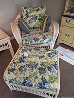 Armchair with cushions and pillows beside ottoman