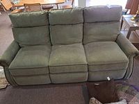 Front view of three-seat upholstered reclining sofa