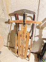 Full view of Flexible Flyer wooden sled leaning against wall
