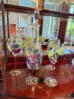 Decanter, wine glasses and one shot glass displayed in cabinet