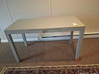 full view of gray rectangular desk with drawer