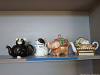 Shelf view showing four animal novelty teapots