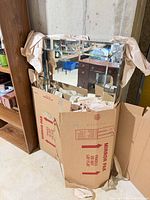 Mirror in cardboard box with packing paper