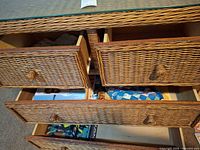 Open wicker dresser drawers showing calendars and quilted piece