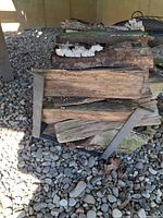 Metal log holder with firewood stacked on it