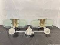 Front view of pair of vintage wall sconces showing chrome bases and frosted oval glass shades