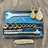 Case open with sockets, drive tools, wrench, hex key, pulleys, utility knife