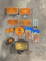 Overview of all amber marker lights, packaged lenses and bulbs laid out on floor