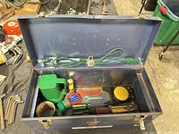 Toolbox opened showing extension cord, padlock, and assorted tools