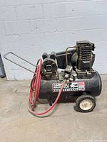 Full view of Campbell Hausfeld compressor with red hose