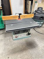 Full view of Delta benchtop router table with wooden fence and bit