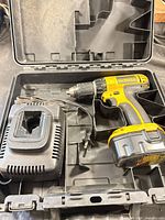 Open case showing drill/driver, charger and battery in molded slots