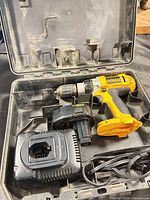 Open case showing DeWALT drill, charger, battery adapter