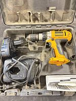 Open case displaying drill, battery, charger, manual