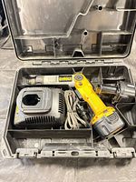Open case showing driver, charger, battery, cord