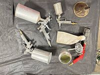 all spray guns, cups, funnel, bag laid out