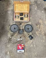 All components laid out: two 8-inch speakers, midrange driver, crossover assemblies, wiring, boxed Thermoid fuel hose
