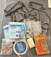 Group shot showing scroll brackets, packaged handles, weatherstripping, tubing, and other hardware