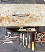 Closed steel toolbox and hand tools laid out
