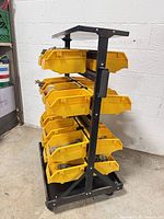 Side view of black metal rack with yellow bins on casters