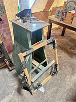 Angled view of pedestal router table with folding sawhorse leaning against it