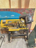 Front view of yellow Power Fist metal cutting bandsaw on stand