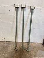 Three steel posts standing upright against wall