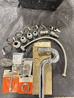 Entire assortment laid out showing P-trap box, hose, clamps, fittings, strainer, washers