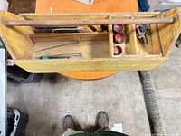 top view of yellow wooden toolbox with handle and contents visible